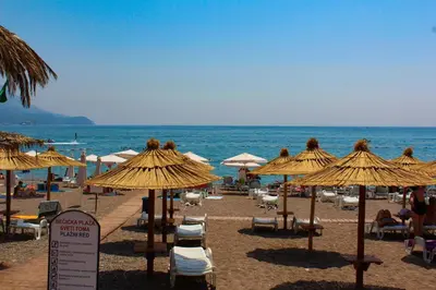 a beach with umbrellas and chairs and the ocean at Bečiči -Big apartments in Becici
