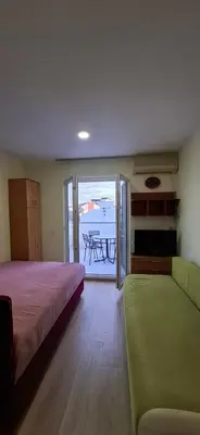 a bedroom with a bed and a couch and a table at Sunčani apartman 2-Vila Amfora in Budva