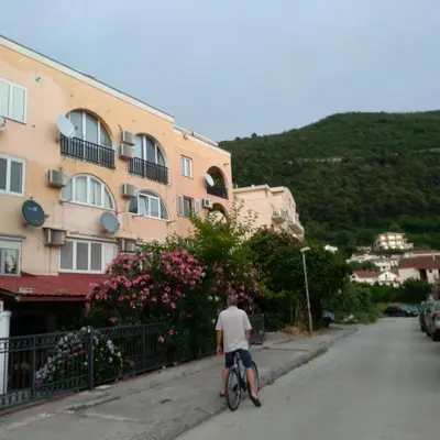 a man riding a bike down a street at Sunčani apartman 2-Vila Amfora in Budva