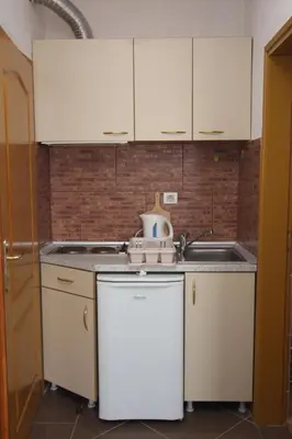a small kitchen with white cabinets and a sink at Villa Beba in Dobra Voda