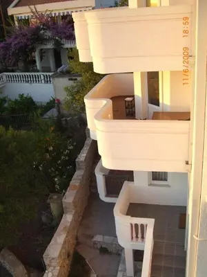 a white building with a staircase in a yard at Villa Beba in Dobra Voda