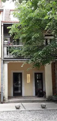 a building with a tree and two entrances to it at Apartman Centar in Cetinje