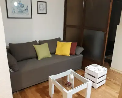 a living room with a gray couch and a table at Apartman Centar in Cetinje