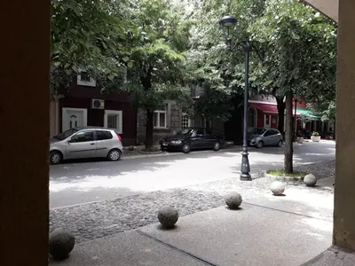 a street with cars parked on a city street at Apartman Centar in Cetinje