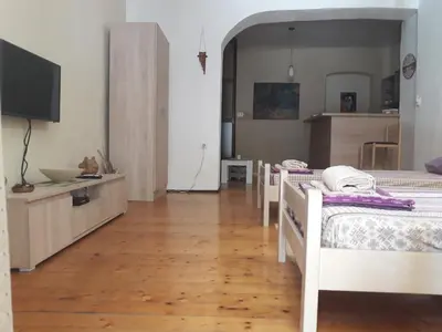 a room with three beds and a television in it at Apartman Centar in Cetinje
