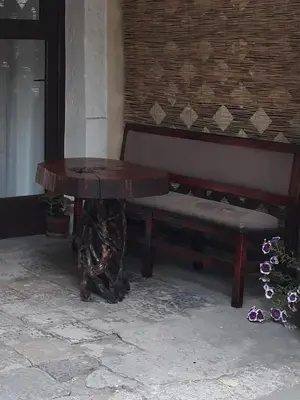 a wooden table and a bench next to a building at Apartman Centar in Cetinje