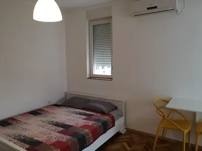 a small bedroom with a bed and a window at Clock Tower Apartments in Podgorica