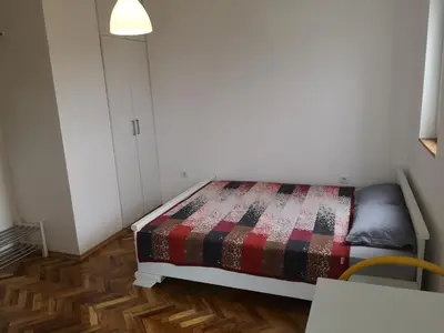 a small bedroom with a bed and a table at Clock Tower Apartments in Podgorica