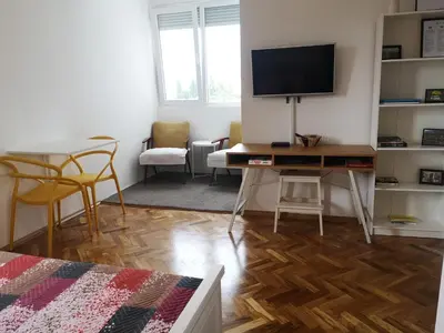 a living room with a desk with a television on it at Clock Tower Apartments in Podgorica
