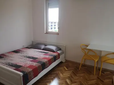 a bedroom with a bed and a table and chairs at Clock Tower Apartments in Podgorica