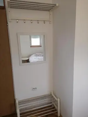 a bedroom with a mirror and a window on the wall at Clock Tower Apartments in Podgorica