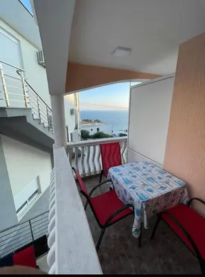 a balcony with a table and chairs and the ocean at Apartments Harmony in Ulcinj