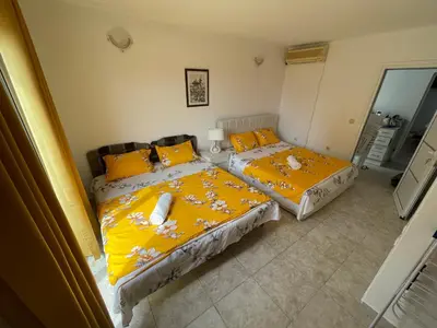 two beds in a room with yellow sheets and yellow pillows at Apartments Harmony in Ulcinj