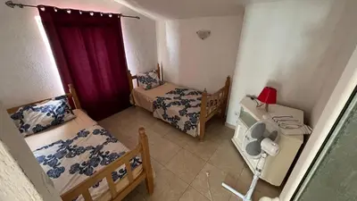a small room with two beds and a table with a fan at Apartments Harmony in Ulcinj