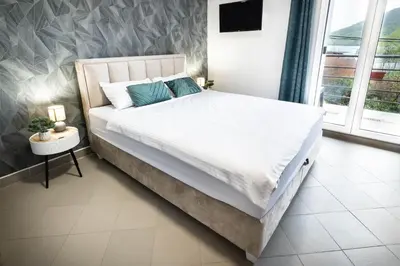 a bedroom with a large bed with white sheets and blue pillows at Studio Apartment Cudo Nevidjeno in Karuč