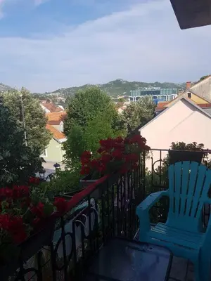 a blue chair sitting on a balcony with flowers at Villa Royal in Cetinje