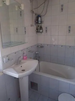 a white bathroom with a sink and a bath tub at Villa Royal in Cetinje