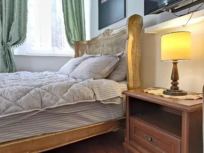 a bedroom with a bed and a table with a lamp at Villa Royal in Cetinje