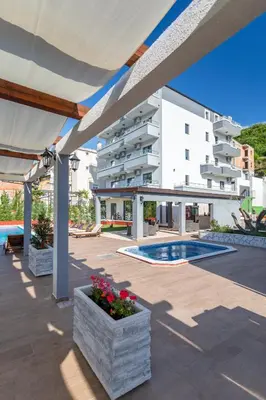 a large white building with a swimming pool at Resort Bevilacqua in Budva