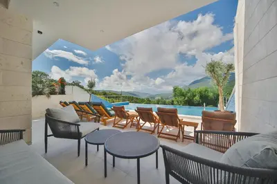 a patio with chairs and tables and a pool at Resort Bevilacqua in Budva