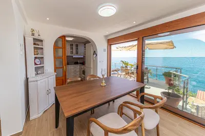 a dining room with a table and a view of the ocean at Vila Dora in Dobra Voda