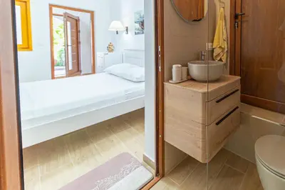 a small bathroom with a bed and a sink at Vila Dora in Dobra Voda
