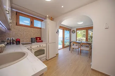 a kitchen with a sink and a table with chairs at Vila Dora in Dobra Voda