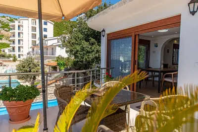 a balcony of a house with a table and chairs at Vila Dora in Dobra Voda