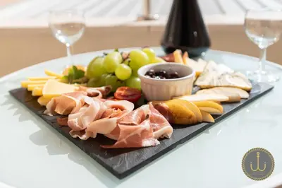 a plate of food on a table with wine glasses at Ancora 2 in Budva