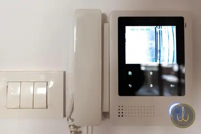 a white phone is sitting next to a lightswitch at Ancora 2 in Budva