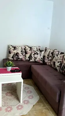 a brown couch in a living room with a table at Apartman Tatjana in Sutomore