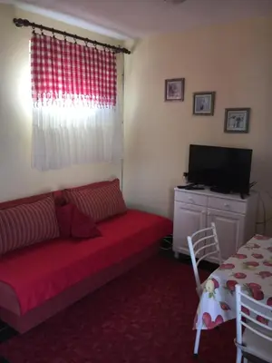a living room with a red couch and a television at Apartman Tatjana in Sutomore