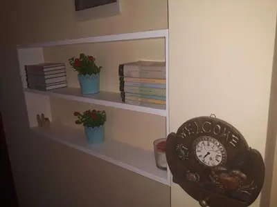 a book shelf with a clock and some books at Apartman Tatjana in Sutomore