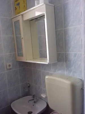 a bathroom with a white cabinet above a toilet at Apartman Tatjana in Sutomore
