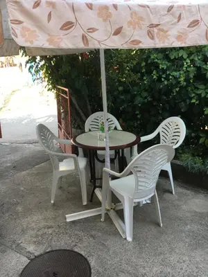 a table with four chairs and an umbrella at Apartman Tatjana in Sutomore