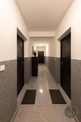 a hallway with black doors and tile floors at Ancora 3 in Budva