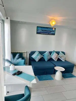 a living room with a blue couch and a table at Beautiful view in Kotor