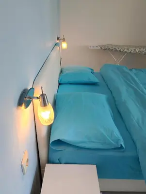 a bed with blue sheets and a lamp next to it at Beautiful view in Kotor