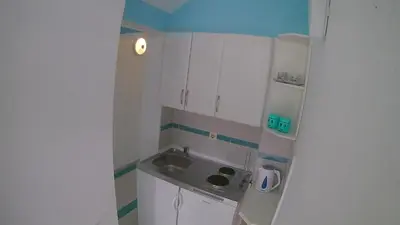 a small kitchen with white cabinets and a sink at Beautiful view in Kotor