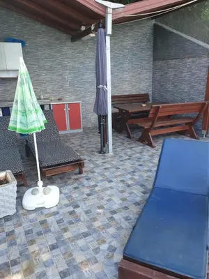 a patio with a table and chairs and an umbrella at Holiday House Kruce in Ulcinj