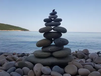 a stack of rocks sitting on a beach at Holiday House Kruce in Ulcinj