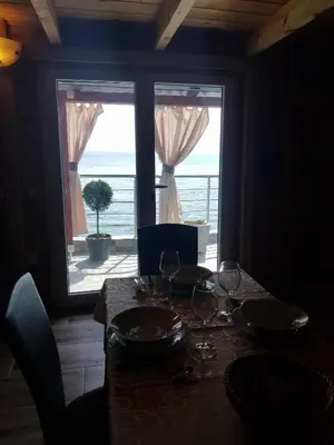 a table with wine glasses and a view of the ocean at Holiday House Kruce in Ulcinj