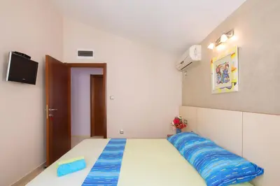 a bedroom with a bed with a blue pillow on it at Vila Hortenzija in Becici