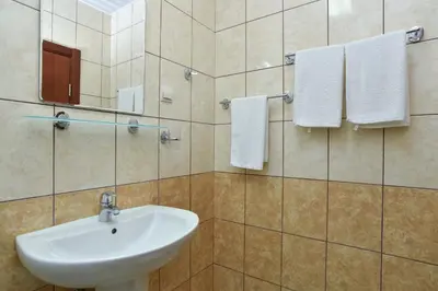 a bathroom with a sink and a mirror and towels at Vila Hortenzija in Becici