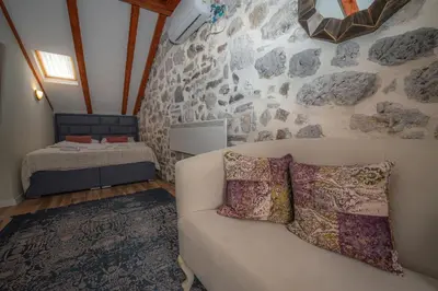 a living room with a couch and a rock wall at Antika Guesthouse in Kotor