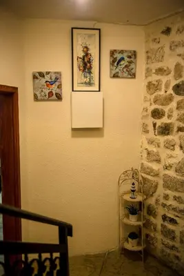 a room with a wall with pictures and a shelf at Antika Guesthouse in Kotor