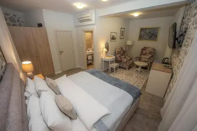 a bedroom with a large bed and a living room at Antika Guesthouse in Kotor