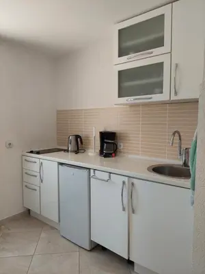 a kitchen with white cabinets and a sink at Strandhaus Adria in Ulcinj