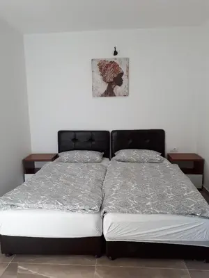 a bed in a bedroom with two night stands at Strandhaus Adria in Ulcinj