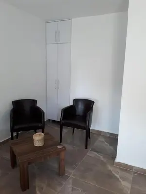 two black chairs and a coffee table in a room at Strandhaus Adria in Ulcinj